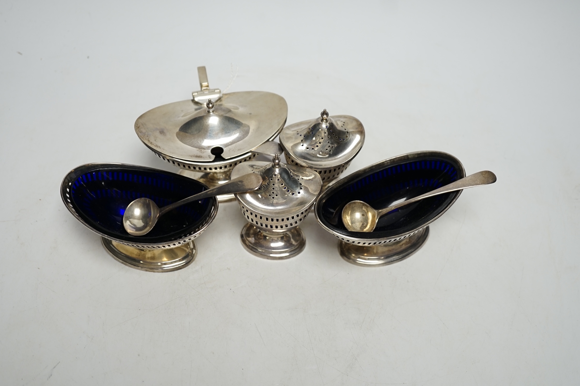 A 1930's George III style five piece silver cruet set, London, 1936/37, with three associated spoons, one silver plated.